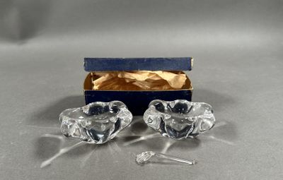 pair of clear glass candlesticks in a blue box on a table