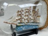 a ship in a glass bottle with a rope around it