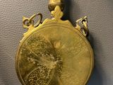 gold plated pocket watch on display in a museum setting