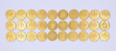 un gros plan sur une rangée de pièces d'or posées sur une surface blanche