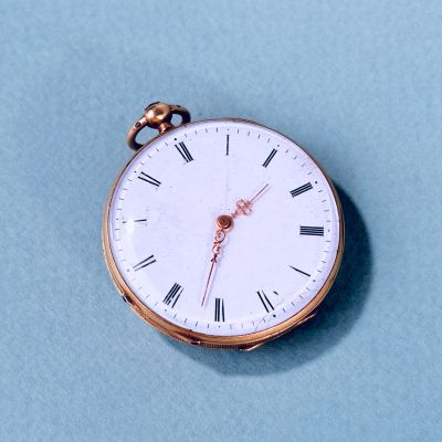 une montre de poche en or avec des chiffres romains sur le cadran