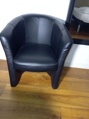 a black chair that is sitting on a wooden floor