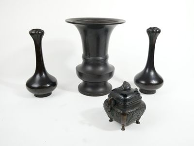 three black vases sitting next to each other on a white surface