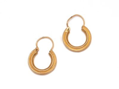 une paire de boucles d'oreilles en or sur fond blanc