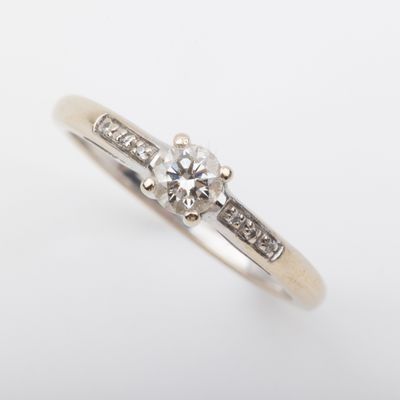 gros plan d'une bague en diamant sur une surface blanche