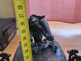 a statue of a bird sitting on top of a bowl with a measuring tape