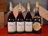 four bottles of wine are lined up on a red table