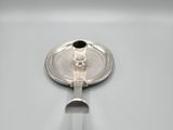 silver plated candle holder with a black candle on top of it