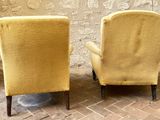 pair of yellow upholstered chairs sitting on a brick floor