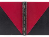 un livre noir et rouge avec une couverture en cuir noir