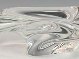 une sculpture en verre représentant une vague sur une surface blanche