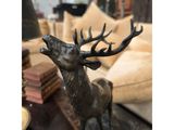 statue of a stag with antlers on a table in a living room