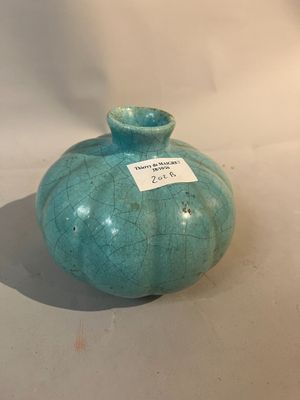 un vase bleu muni d'une étiquette, posé sur une table