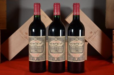 three bottles of red wine sitting on a table next to a wooden box