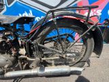 une vieille moto garée devant un bus
