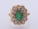 a close up of a gold ring with a green emerald and white diamonds