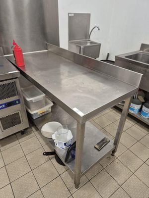 une grande table en acier inoxydable dans une cuisine professionnelle