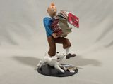 figurine of a man carrying a stack of books and a white cat