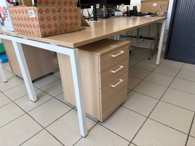 a desk with a computer monitor and a file cabinet on it