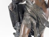 bronze statue of a man holding a book on a white background
