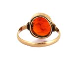 an image of a gold ring with an orange stone in the center