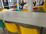 yellow and green chairs and a white table in a large room