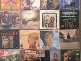 a lot of different vinyl records on the wall