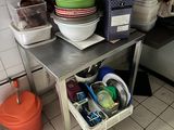un coin cuisine équipé d'un évier et d'une table sur laquelle sont posés des bols et des casseroles
