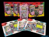 un gros plan sur quatre paquets de cartes Pokémon sur fond noir