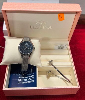 une photo d'une montre dans un coffret posée sur un tapis rouge