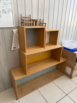 a wooden shelf with two chairs on top of it