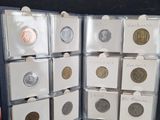 a person holding a coin in a case with other coins in it