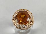 a close up of a ring with an orange stone in it