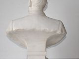 white marble bust of a man on a pedestal on a white background