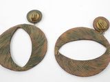 pair of wooden earrings with a circular design on the front and a circular design on the back