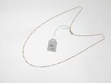 un collier auquel est attachée une étiquette sur une surface blanche