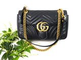 Sac à bandoulière Guccissi en cuir noir, avec finitions dorées et chaîne