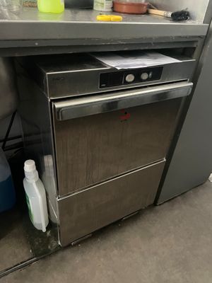 une cuisine équipée d'une cuisinière, d'un lave-vaisselle et d'autres objets posés sur le plan de travail