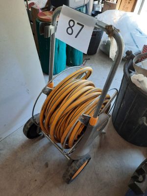 a cart with a hose on it in a garage
