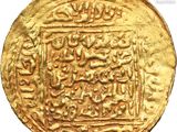 a close up of a gold coin with arabic writing on it