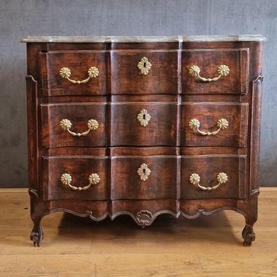 an antique chest of drawers with marble top and brass handles