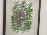 painting of a cat in a frame hanging on a wall