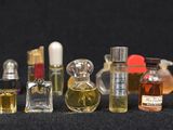 many different types of perfume bottles lined up on a black surface