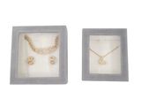 a couple of necklaces and earrings in a box on a white background