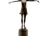 bronze statue of a woman standing on a pedestal with her arms outstretched