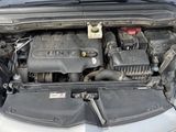 une voiture dont le capot est ouvert et dont le moteur se trouve dans le coffre