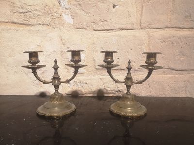 three candles that are on a table in front of a brick wall