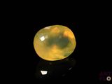 a close up of a yellow jade stone on a black surface