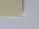 a piece of paper on a white surface with a small hole in it