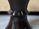 un tabouret noir avec un piètement en bois dans une pièce
